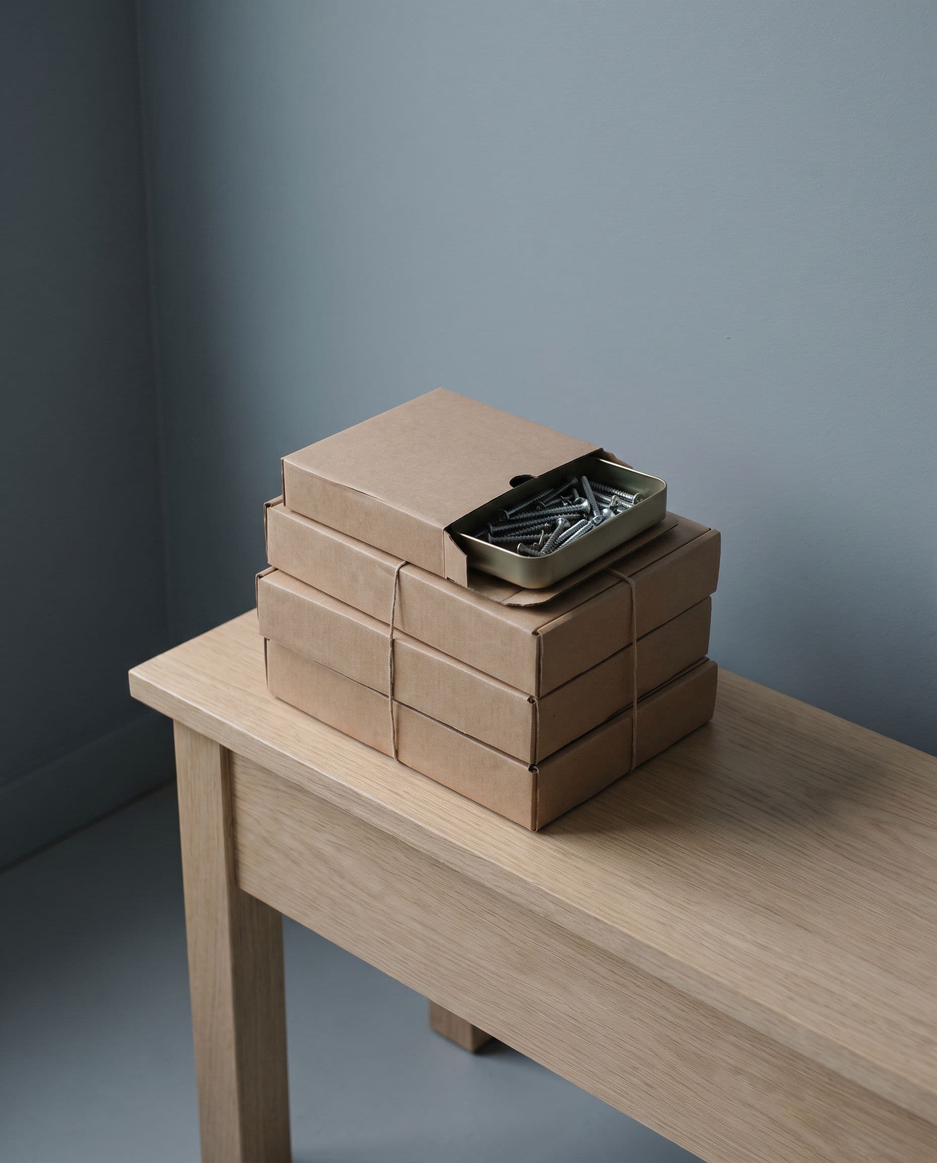 Courier boxes on a bench, one open to show screws