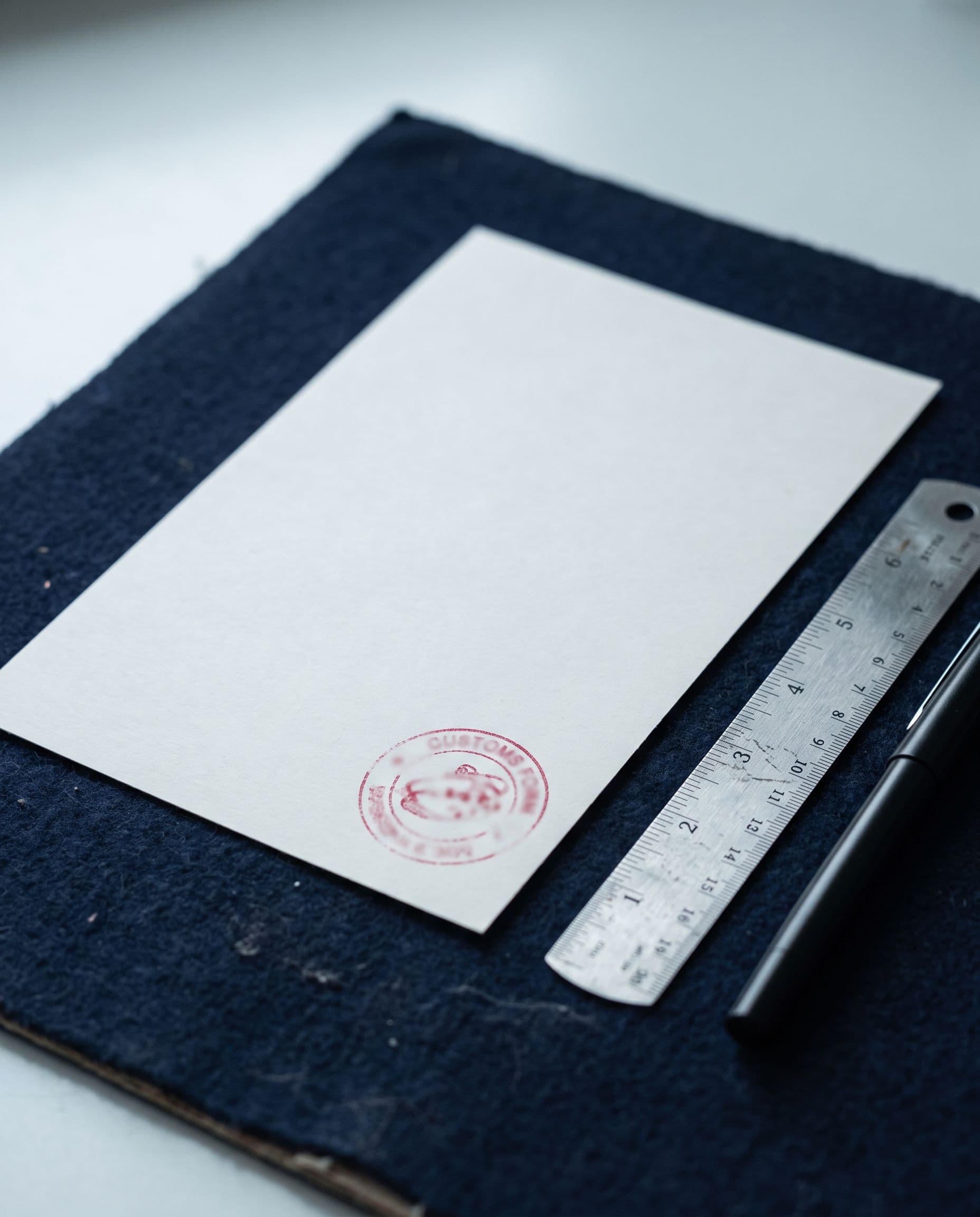 A blank form with a red stamp on a navy blotter